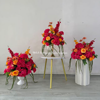 Centre de table floral artificiel éclatant, fleurs rose vif et orange, idéal pour la décoration de tables de mariage et les événements de banquet.