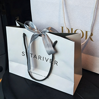 Sac cadeau élégant en papier blanc avec intérieur noir, poignée en corde, logo de la marque pour magasin de vêtements