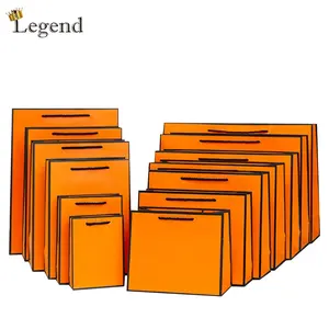 Borsa di imballaggio di carta per lo Shopping all'ingrosso con il tuo Logo arancione stampa personalizzata materiale riciclato sacchetto di carta personalizzato