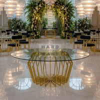 Table de salle à manger moderne pour hôtel avec plateau en verre rond et structure en acier inoxydable pour les événements de mariage et de banquet