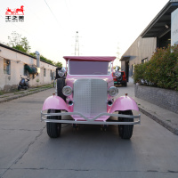 Roadster électrique de style antique avec capote blanche et phares doubles pour les balades en bord de mer et les promenades dans les parcs
