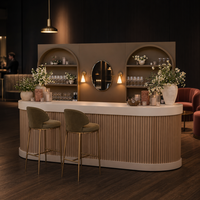 Comptoir de bar événementiel modulaire arrondi en lattes de bois brun mat avec miroir ovale et appliques murales dorées pour location de mobilier de fête