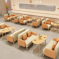 Ensemble de mobilier de restaurant commercial : Canapés deux places beige et vert, table basse ovale en bois moderne et durable avec pieds géométriques