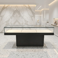 Comptoir de vente au détail moderne sur mesure avec plateau en verre, vitrine îlot pour bijoux, noir mat, longue vitrine de luxe pour boutique avec éclairage LED
