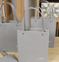 Sac en papier blanc personnalisé avec estampage à chaud et finition UV sélective, ODM OEM pour l'emballage de marques de luxe