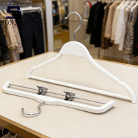 Cintres en plastique blanc à logo personnalisé, design minimaliste, robustes et peu encombrants pour magasin
