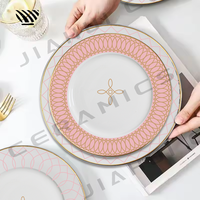 Charmant ensemble de vaisselle en porcelaine motifs roses délicats avec des accents dorés pour les tables de mariage de rêve