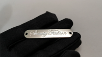 Étiquette ovale en métal argenté de haute qualité logo de marque personnalisé plaque d'étiquette en métal pour vêtement