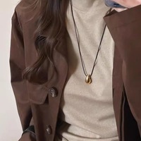 Collier long en alliage bicolore or et argent avec pendentif goutte d'eau et cordon en cuir noir pour femme, idéal pour un style décontracté, urbain ou quotidien, parfait comme cadeau.