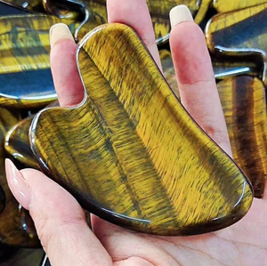 Gua Sha de ojo de tigre natural en forma de corazon color marron para masaje facial - Product Image 1