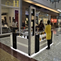 Kiosque de luxe noir et or pour parfums, présentoirs de parfums, présentoir de parfums avec sièges bar pour clients
