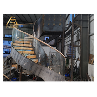 Escalier hélicoïdal courbé avec poutre continue en acier, remplissage en panneaux de verre et éclairage LED intégré aux marches