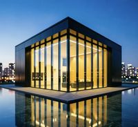Villa minimaliste avec mur-rideau en verre et structure en acier, dotée d'un système d'éclairage nocturne