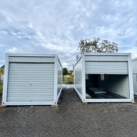 Bâtiment modulaire préfabriqué à façade ouverte avec garage, structure blanche, coins profilés et toit plat, pour cour, place publique et stockage