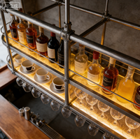 Porte-bouteilles suspendu en acier inoxydable industriel avec éclairage LED, design multi-niveaux pour le rangement des bouteilles et des verres, idéal pour les bars commerciaux modernes