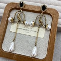 Boucles d'oreilles rétro exagérées en forme de cage à oiseaux dorée avec perles