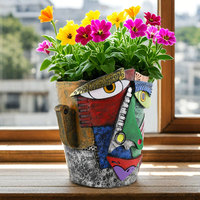 Pot de fleurs en résine avec visage abstrait coloré et fleurs roses pour décoration intérieure
