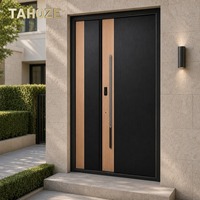 Porte d'entrée de sécurité en acier finition grain de bois noir avec garniture en bois clair et poignée intégrée pour villa privée