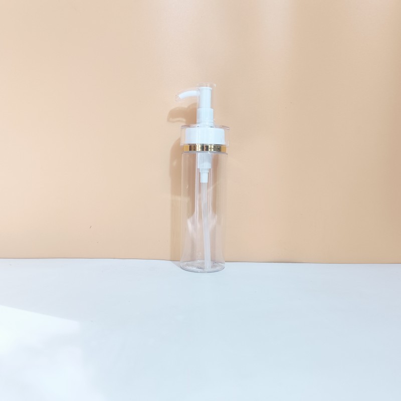 Botella transparente con bomba de borde dorado.