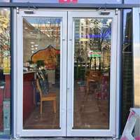 Porte de restaurant en verre trempé à double battant, design postmoderne style KFC, en alliage d'aluminium, avec charnières au sol de style couronne