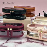 Trousse de Maquillage Portable Ovale en PVC Transparent avec Logo Personnalisé, Poignée Souple en PU, Fermeture Éclair Double Dorée, Étanche TSA