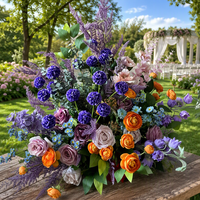Centerpiece bunga pernikahan warna biru dusty dan oranye terang, terbuat dari sutra hydrangea dan mawar dengan dudukan logam emas untuk dekorasi lorong rumput.