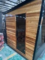 Sauna moderne en cèdre rouge avec cadre noir, verre haut et chauffage à pierres, pour jardin, vente en gros