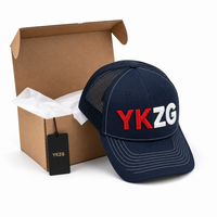 Casquette Trucker personnalisée noire avec broderie 3D en relief, profil haut, 5 panneaux, maille A-Frame, surpiqûres contrastantes blanches, avec boîte et étiquette