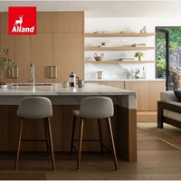 Cuisine moderne en placage de chêne blanc, définie par des veines de marbre spectaculaires, avec une île sculpturale en demi-cascade et une armoire de rangement en panneaux de marbre.