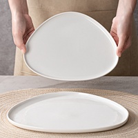 Assiette à dîner en céramique blanche pure, forme irrégulière, passe au micro-ondes, design moderne minimaliste, assiette plate peu profonde pour la maison