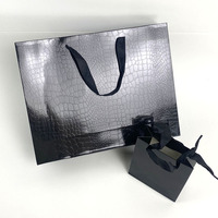 Sac en papier noir personnalisable avec motifs lézards et crocodiles, film brillant, sac cadeau haut de gamme et tendance pour magasin de vêtements