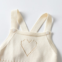 Combinaison bébé en coton pur minimaliste, tricotée, avec détail cœur ajouré, bretelles croisées, sans manches