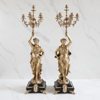 Une paire de chandeliers à 6 bras de style rococo, en laiton ornementé et marbre noir/rouge/vert, avec des statues figurées de la déesse de la Lumière en or 24 carats.