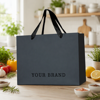 Sac shopping personnalisé en papier métallisé argenté avec logo noir et larges poignées en ruban de satin noir pour vêtements de luxe