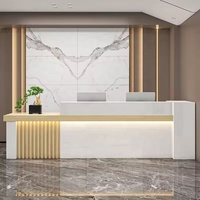 Bureau d'accueil moderne avec panneau frontal aspect marbre, accent en lattes de bois et deux postes de travail
