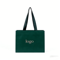 Sac d'emballage cadeau boutique en papier kraft noir recyclé écologique avec logo personnalisé et poignée pour la promotion de vêtements