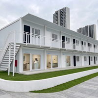 Maison modulaire à deux étages en conteneurs, cabane préfabriquée à ossature acier avec balcon et couloir pour hébergement, bureau ou location.