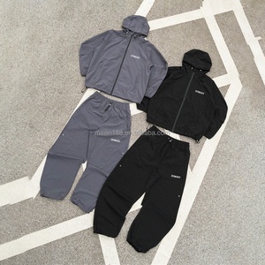 Ensemble de survêtement coupe-vent personnalisé en usine : veste zippée en polyester et pantalon en nylon, ensemble deux pièces léger pour le jogging - Product Image 1