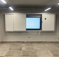 Tableau blanc coulissant interactif avec écran numérique intégré dans un meuble plat