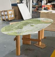Table à manger ovale en marbre vert émeraude, plateau en pierre veinée verte et blanche, pieds cylindriques en bois naturel, style moderne et luxueux pour maison/villa/restaurant