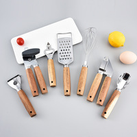 Ensemble d'ustensiles de cuisine en acier inoxydable avec manche en bois : râpe, ouvre-boîte, couteau à pizza, outils de cuisson, de découpe et de service