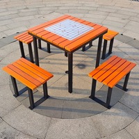 Table d'échecs d'extérieur moderne en teck et MDF avec structure métallique et quatre chaises pour la restauration hôtelière et les jeux d'échecs