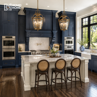 Meubles de cuisine sur mesure bleu marine américain, cheminée coloniale, hotte de cuisine, double four, lanternes vintage en laiton, armoires de style manoir