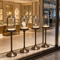 Ensemble de vitrines à bijoux avec vitrine en verre cintrée, piédestal en métal bronze et éclairage LED pour la présentation en vitrine de bijouterie