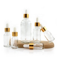 Flacon compte-gouttes en verre vide avec col fileté, collier doré et insert à bille blanche pour emballage cosmétique d'huiles essentielles et de sérums