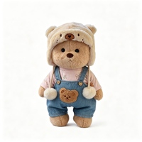 Peluche Ours Marron Adorable avec Chapeau de Trappeur et Salopette en Jean – Jouet en Peluche Doux et Tendance