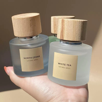 Grosir desain baru botol parfum kaca bening buram bulat kapasitas 30ml 50ml 100ml dengan topi kayu untuk Makeup