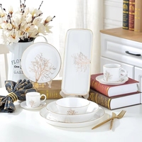 Service de table en porcelaine peinte à la main avec bordure dorée, style luxe léger, design végétal moderne et épuré, comprenant assiettes, bols à dessert, à fruits, à salade et à soupe