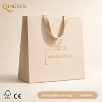 Sac de shopping en papier crème OEM personnalisé, boîte cadeau avec logo imprimé en feuille d'or, poignées larges en ruban satiné pour boutique de détail
