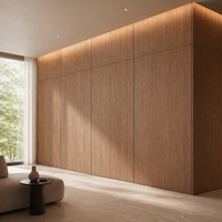 Revêtement mural en placage de bois avec grands modules, joints fins, coins recouverts et éclairage linéaire intégré pour les intérieurs